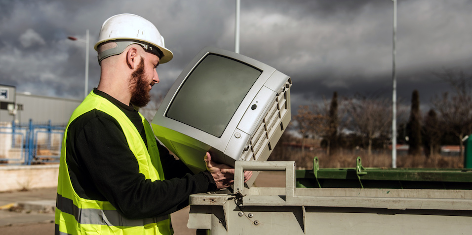 E-waste recycler recycling an old TV